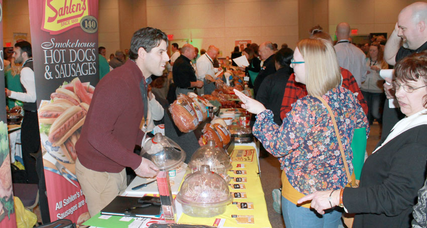 trade show picture of vendors at food table