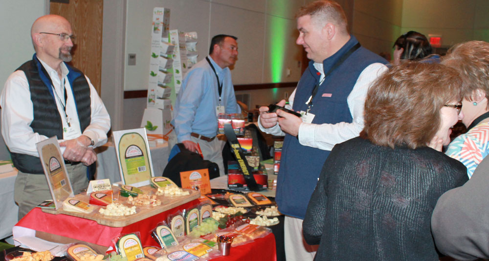 trade show picture of vendors at food table talking to customers