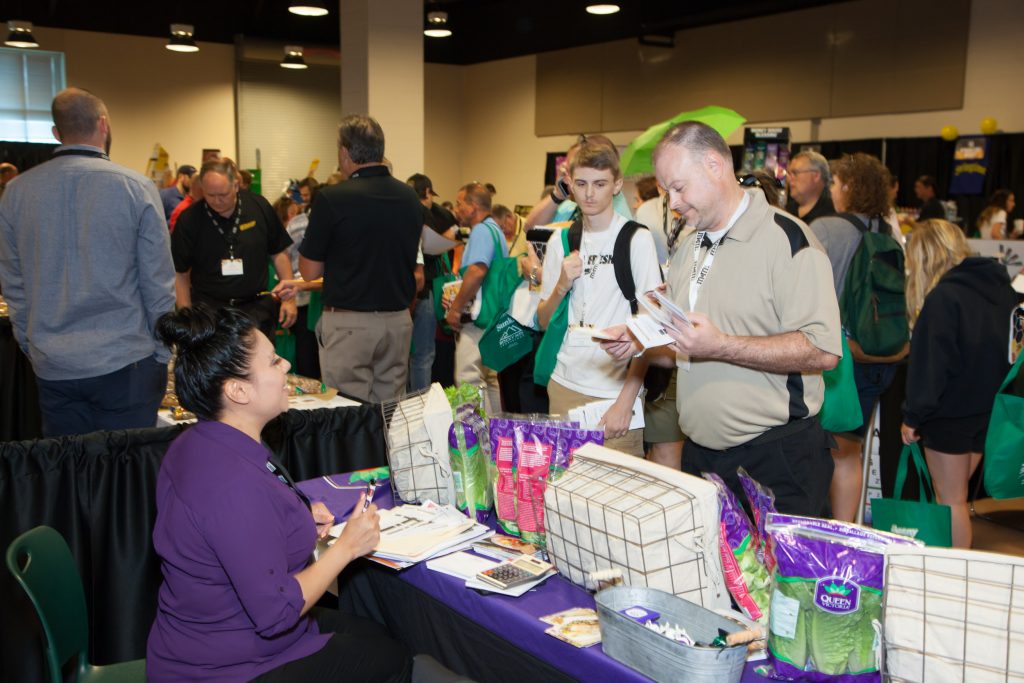 trade show picture of vendors at food table talking to customers