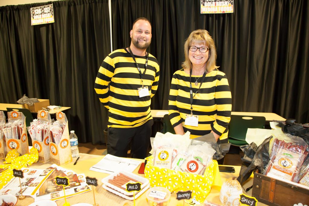 trade show picture of vendors at food table talking to customers