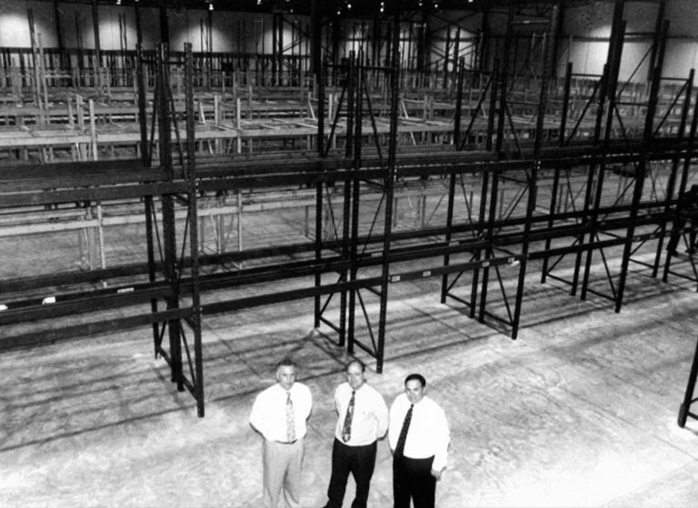 Warehouse Brothers warehouse when it was empty. 3 brothers standing in front of shelves